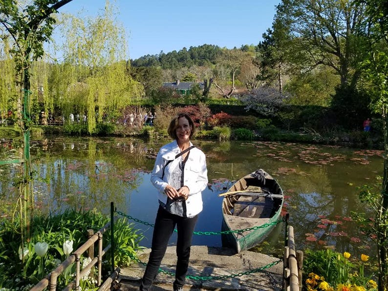 a woman standing on a dock next to a boat