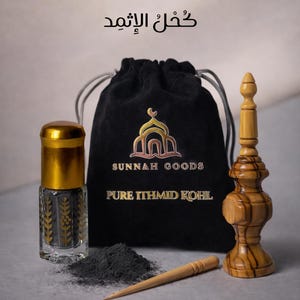 May include: An assortment of Ithmid Kohl products. A clear glass bottle with a gold cap and a black powder inside sits next to a black drawstring bag with gold lettering. A wooden applicator and a decorative wooden piece are also present.