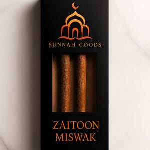 May include: Black box with a window displaying two brown Zaitoon Miswak sticks. The box features the text "SUNNAH GOODS" and "ZAITOON MISWAK" in orange. An orange mosque logo is at the top.