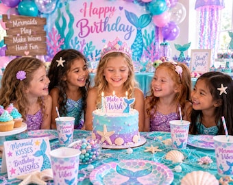 May include: A birthday party table setting with a blue and purple ombre cake featuring a starfish and seashell topper, surrounded by Mermaid Vibes paper cups, plates, and a sign that reads Mermaid Kisses and Birthday WISHES in a room.