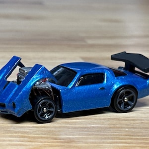 Custom made Hot Wheels 1979 Camaro. Tilted hood reveals a huge power plant with plug wires  and headers. Beautifully done in Electric Blue.