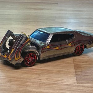 Costom made Hot Wheels 1970 Buick GSX. The front tilts open and shut, exposing a huge power plant, headers, and plug wires. Very cool