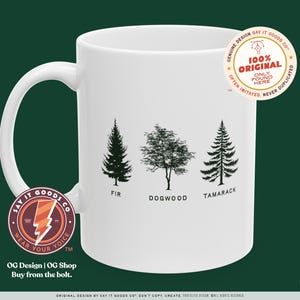 Può includere: Una tazza in ceramica bianca con una silhouette nera di un abete, un corniolo e un larice. La tazza ha un logo nero e rosso che dice "Say It Goods Co. Wear Your Voice" e il testo "OG Design | OG Shop Buy from the bolt."