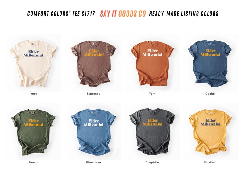 Elder Millennial graphic tee in Graphite color, made from Comfort Colors® C1717 shirt. The design features bold text in vintage-style font with 'Elder Millennial' printed in mustard yellow across the front. Available in multiple colors including Ivory, Espresso, Yam, Denim, Hemp, Blue Jean, Graphite, and Mustard. A perfect t-shirt for millennials embracing their unique experiences, including the 90s and early 2000s nostalgia.