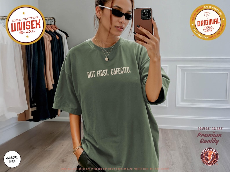 K&ouml;nnte beinhalten: Ein unisex T-Shirt in Moosgr&uuml;n mit dem wei&szlig;en Schriftzug "BUT FIRST. CAFECITO.". Das Shirt besteht aus 100% Baumwolle und ist in den Gr&ouml;&szlig;en S-4XL erh&auml;ltlich. Es geh&ouml;rt zur Comfort Colors Premium Quality Kollektion.
