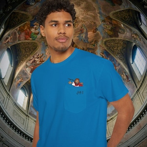 May include: A turquoise blue t-shirt with a pocket featuring a cartoon image of Jesus with the text "I love you." Below the image is Japanese text. The shirt is made of a soft material.