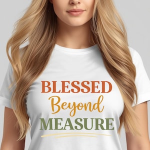 Op de afbeelding: Wit t-shirt met de tekst "BLESSED Beyond MEASURE" in oranje, geel en groen. Het t-shirt heeft een ronde hals en korte mouwen. De tekst is gecentreerd op de voorkant van het kledingstuk.