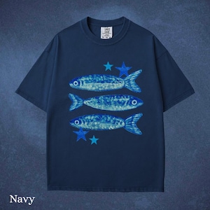May include: Navy blue t-shirt featuring a design of three blue fish and blue stars. The shirt has a crew neck and short sleeves. The text "Comfort Cruise" is printed on the upper right of the shirt.