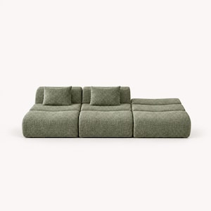 May include: A low-profile modular sofa upholstered in a textured sage green fabric. The piece consists of three connected sections with rounded edges and features two matching square throw pillows placed on the backrests of the first two segments.