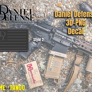 May include: A black and gray Daniel Defense 3D-PNG decal with the text "Daniel Defense 3D-PNG Decal" and "Style 2". The decal is on a brown and green background with a rifle and a magazine.