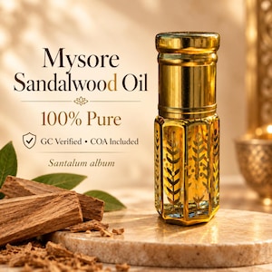 May include: A glass bottle of Mysore Sandalwood Oil with a gold cap and etched leaf patterns. The text reads: Mysore Sandalwood Oil, 100% Pure, GC Verified, COA Included, Santalum album. Raw sandalwood pieces and green leaves are nearby.