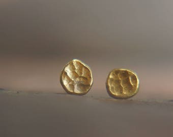 May include: A pair of gold-toned textured round stud earrings.