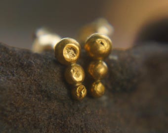 Puede incluir: Pendientes de oro con un racimo de pequeñas cuentas redondas.