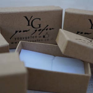 Puede incluir: Cuatro cajas de cart&oacute;n marr&oacute;n con interior blanco. Las cajas est&aacute;n etiquetadas con el texto "YG your gift" y una direcci&oacute;n de sitio web. Las cajas est&aacute;n dispuestas en forma escalonada.