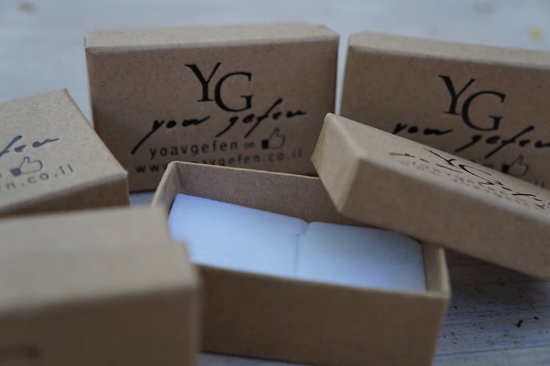 Puede incluir: Cuatro cajas de cart&oacute;n marr&oacute;n con interior blanco. Las cajas est&aacute;n etiquetadas con el texto "YG your gift" y una direcci&oacute;n de sitio web. Las cajas est&aacute;n dispuestas en forma escalonada.