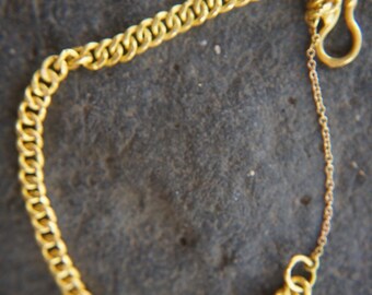 May include: A gold chain bracelet with a curb link design and a lobster clasp closure.