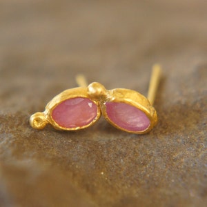 Puede incluir: Un par de pendientes de oro con piedras preciosas ovaladas de color rosa. Los pendientes est&aacute;n engastados en un dise&ntilde;o simple y elegante.