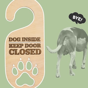 Puede incluir: Colgador de puerta de madera con el texto "DOG INSIDE KEEP DOOR CLOSED" y un diseño de huella de pata. Se muestra un perro alejándose con un bocadillo que dice "BYE!" sobre un fondo verde.