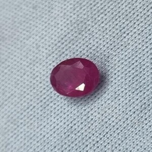 May include: A vibrant pink oval-shaped gemstone with a faceted cut.