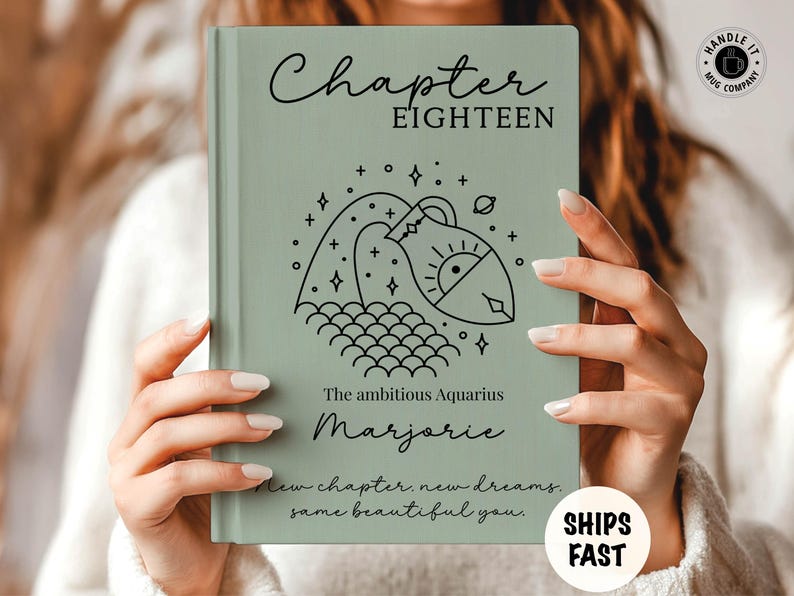 May include: A sage green hardcover book featuring the text Chapter EIGHTEEN, a black line art illustration of the Aquarius zodiac symbol, the text The ambitious Aquarius, the name Marjorie, and the phrase New chapter. new dreams. same beautiful you.