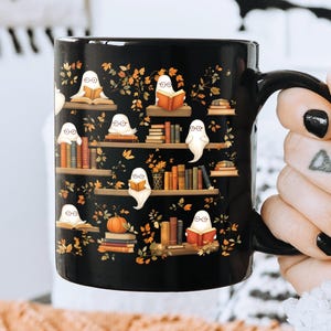 Bookworm girl holding her Halloween mug gift with ghosts reading books pattern.