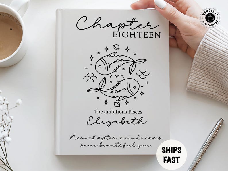 May include: A white hardcover book featuring the text Chapter Eighteen, a black line art illustration of two fish representing the Pisces zodiac sign, the name Elizabeth, and the phrase New chapter, new dreams, same beautiful you printed in black.