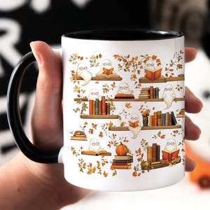 Bibliophile holding her ghost pattern Halloween mug gift.