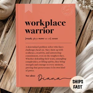 以下が含まれることがあります： 「workplace warrior」という言葉が黒い太字で書かれた、コーラル色の本。 「workplace warrior」の定義が下に印刷されています。 本には「Diana」という名前と「Ships Fast」という言葉も含まれています。