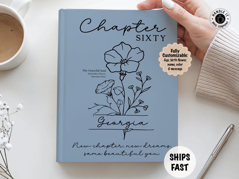 May include: A light blue journal with the words "Chapter SIXTY" in black script. A black floral illustration and the name "Georgia" are featured. Text includes "New chapter, new dreams, same beautiful you."