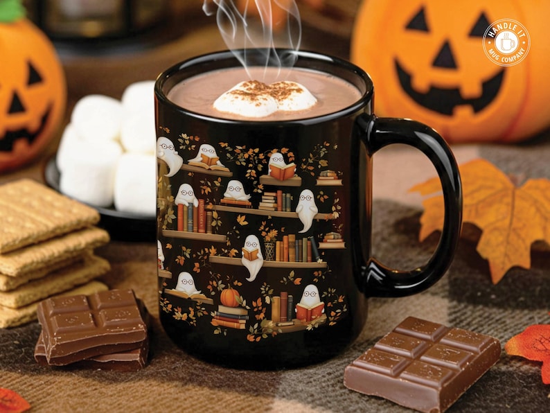 A Halloween cute ghosts reading books pattern mug with a Halloween backdrop of pumpkins and sweets.