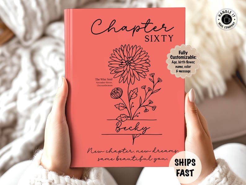 May include: A coral-colored book with the words "Chapter Sixty" in black script. A floral illustration and the name "Becky" are below. Text reads "New chapter, new dreams, same beautiful you." The book is customizable.