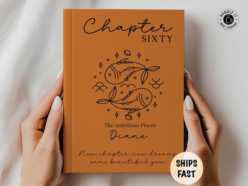 May include: An orange book cover with the words "Chapter SIXTY" in black script. Below is a Pisces design and the name "Diane". The text "New chapter, new dreams, same beautiful you" is also present. A sticker says "SHIPS FAST".