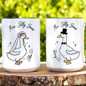 His and hers wedding, engagement or bridal shower mug gift set. Both mugs have a beautiful illustration of Mr Silly Goose (for him), and Mrs Silly Goose (for her). The image shows this masterpiece of a wedding keepsake sitting on a tree stump with lush greenery as the backdrop. Great gift for a friend, son, daughter or daughter in law on his/her wedding. It comes in 11oz, 15oz and 20oz variants and allows for personalization.