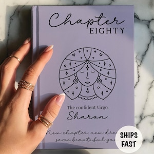 Puede incluir: Un libro de tapa dura de color morado claro con el texto Chapter EIGHTY, una ilustración de líneas negras de una persona con cabello largo, el texto The confident Virgo Sharon y el texto New chapter, new dreams, same beautiful you.