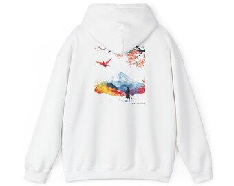 May include: White hoodie featuring a colorful watercolor design on the back. The design includes a mountain, a red origami crane, and cherry blossoms. The hoodie has a drawstring hood and a kangaroo pocket.
