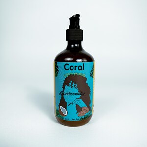 Puede incluir: Una botella marrón de acondicionador orgánico Coral con un dispensador de bomba negro. La etiqueta es turquesa con el nombre de la marca y la palabra "Acondicionador" en blanco. Un gráfico de cabello de mujer y un coco también están en la etiqueta.