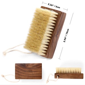 May include: A wooden nail brush with natural bristles. The brush measures 3.94 inches (10 cm) long and 2.36 inches (6 cm) wide. It has a dark brown wooden handle and a loop for hanging.