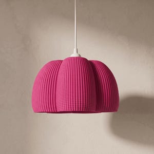 May include: A vibrant magenta pendant light fitting featuring a rounded, pumpkin-like shape with deep vertical ridges. The lamp shade is suspended from a simple white cord and includes a white circular mounting cap at the top centre.