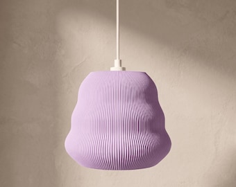 Puede incluir: Una lámpara colgante de color lavanda con una pantalla redondeada en forma de campana y una textura acanalada vertical. La lámpara cuelga de un cable blanco fino unido a un soporte de techo circular blanco en la parte superior.