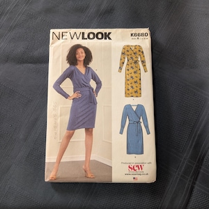 May include: A New Look K6680 sewing pattern envelope featuring a wrap dress design. The front shows a model in a blue dress and illustrations of a yellow floral dress and a blue dress, both with long sleeves, a V-neckline, and a tie waist belt.