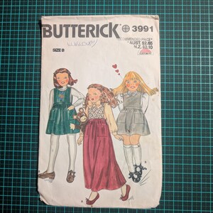 May include: Vintage Butterick sewing pattern 3991, size B. The cover art depicts three young girls in dresses. The pattern includes the recommended price in Australian and New Zealand currency. The cover shows signs of wear.