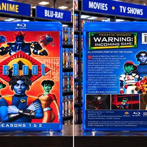 May include: A blue Blu-ray case for the animated series ReBoot, featuring seasons 1 and 2. The front cover displays the title and characters, while the back cover includes a synopsis, episode count, barcode, and technical specifications.