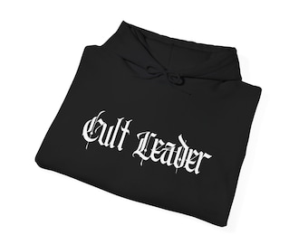 Könnte beinhalten: Schwarzer Kapuzenpullover mit dem weißen Schriftzug "Cult Leader" in gotischer Schrift. Der Hoodie hat eine Kapuze mit Kordelzug und ist ordentlich gefaltet. Der Text ist deutlich sichtbar.