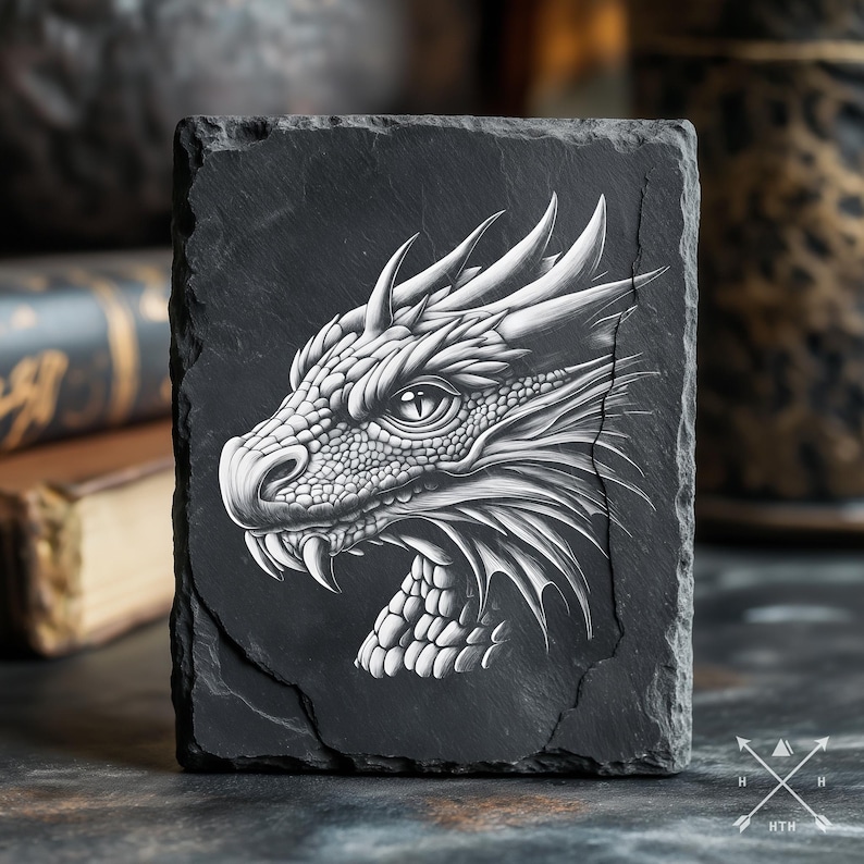 May include: A black slate coaster with a white detailed drawing of a dragon's head.