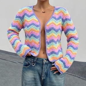 May include: A colorful, open-front crochet cardigan in a chevron pattern. The sweater features a V-neck and long sleeves. The color palette includes pastel shades of pink, orange, yellow, green, and blue.