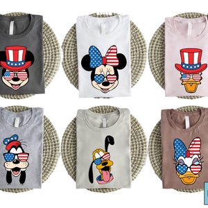 Maglietta con volti Disney patriottici, maglietta per il 4 luglio con Topolino, Paperino, Paperina, Pippo e Pluto, maglietta con bandiera americana e occhiali.