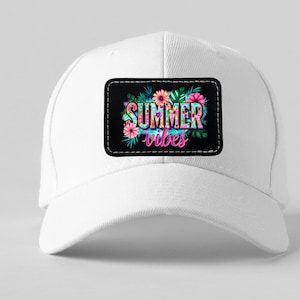 Puede incluir: Gorra de béisbol blanca con un parche negro con la inscripción "SUMMER vibes" en letras coloridas y florales. El diseño incluye flores rosas y naranjas, hojas verdes y una vibrante combinación de colores tropicales.