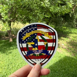 May include: A shield-shaped sticker featuring the Texas Department of Public Safety and Texas Highway Patrol emblems. It displays a central star, the Texas state outline, and the text 1776-2026 250 YEARS over a red, white, and blue flag design.