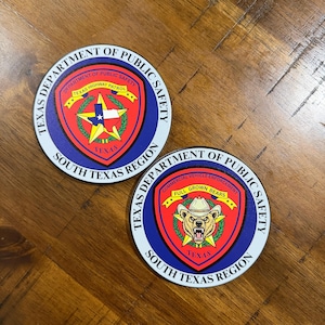 May include: Two circular patches featuring the Texas Department of Public Safety South Texas Region emblem. One displays a star with the Texas flag, the other a bear wearing a cowboy hat with the text Full Grown Bears and Commercial Vehicle Enforcement.