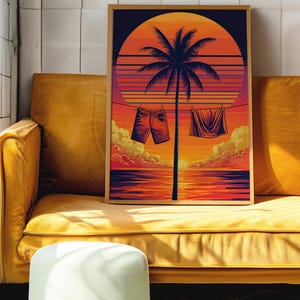 Puede incluir: Una impresión artística enmarcada que presenta una escena de atardecer retro con una silueta de palmera. La ropa cuelga de una cuerda frente a la puesta de sol. La obra de arte se exhibe en un sofá amarillo.